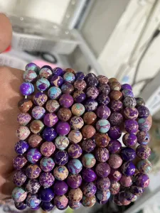 Detailed close-up of purple and blue imperial jasper gemstone beads, showing natural patterns.
