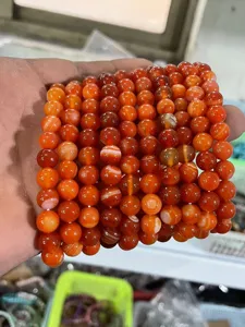 Detailed view of natural 8mm red agate gemstone beaded bracelets, handmade stacked jewelry.