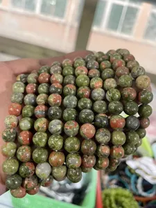 Close-up detail of polished multi-color natural gemstone beads strands showing unique texture.