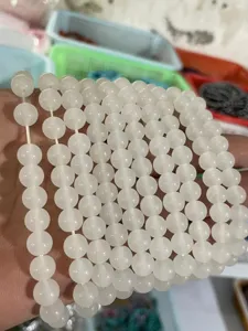Close-up detail of white gemstone round beads strands, ideal for DIY handmade jewelry making.