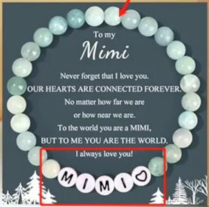 Close up detail of handmade beaded bracelet with letter charms and sentimental message card.