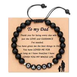 Close-up detail of the black beaded dad bracelet with kraft card and custom letter beads.