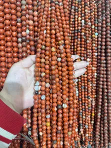 Primer plano de hebra de cuentas redondas de jaspe rojo para abalorios y joyeria al por mayor.