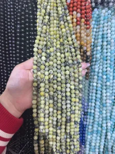 Primer plano detallado de cuentas redondas de piedra natural en exhibicion al por mayor.