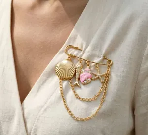 Close-up detail van strandvakantie stijl broche met roze schelp en meerdere ketting.