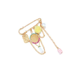 Detailed view of rhinestone badminton racket brooch, golden alloy chain pendant, fashion jewelry.