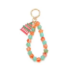 Close-up detail of the Chinese style pagoda pendant and colorful star beads on a gold keychain.