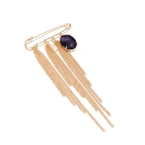 Broche de imperdible dorado con pedrería violeta y detalles de cadenas de varias capas.