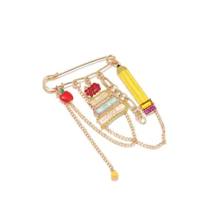 Close-up of school-themed rhinestone brooch with pencil book and apple charms detail.