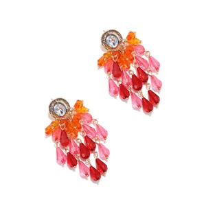 Close-up of sparkling long acrylic tassel earrings with vibrant pink, red and orange beads.
