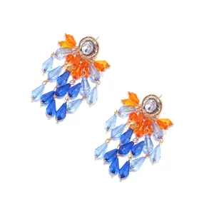 Closeup detail of colorful crystal tassel earrings with blue and orange teardrop beads.