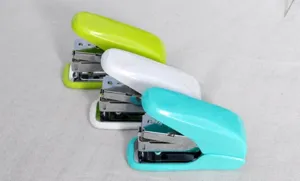 Detailopname van compacte kleurrijke kantoornietmachines in groen, wit en lichtblauwe uitvoering.