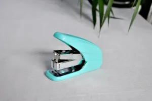Detailopname van de ergonomische bureau-nietmachine in levendige turquoise kleur, kantooritem.