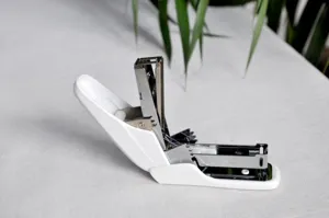 Gedetailleerd overzicht van witte ergonomische kantoor nietmachine met metalen mechanisme.