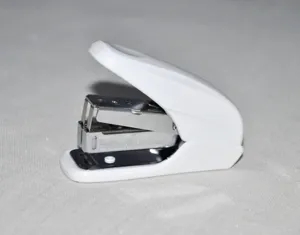 Gedetailleerd overzicht van een wit plastic bureau-nietmachine met metalen mechanisme.