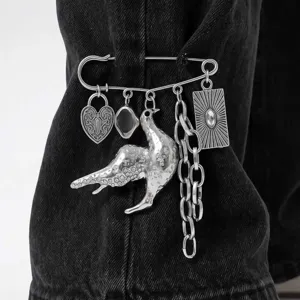 Close-up detailopname van punk metalen veiligheidsspeld broche met duif en ketting hangers.