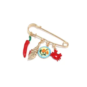 Jolie broche émaillée avec pendentifs piment, coquillage et crabe. Accessoire mode doré chic.