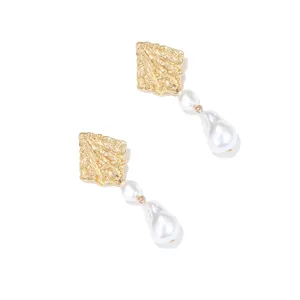 Exquisitos pendientes dorados con textura y perlas barrocas, elegante diseño vintage.
