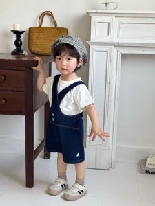Grazioso set salopette in denim per neonati con t-shirt bianca e berretto a quadri estivo.
