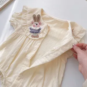 Primo piano sul dettaglio del colletto della tutina da bambina con coniglio 3D e pizzo.