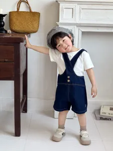 Set estivo carino per neonati con salopette di jeans, t-shirt bianca e berretto a quadri.