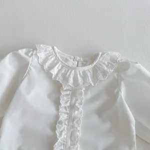 White baby blouse detail featuring delicate lace ruffled collar and long sleeves for infants.