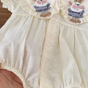 Primo piano dettagliato di romper in cotone per neonati con collo a coniglietto morbido.