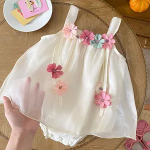 Dettaglio della tutina estiva per neonata con fiori delicati e spalline trasparenti.