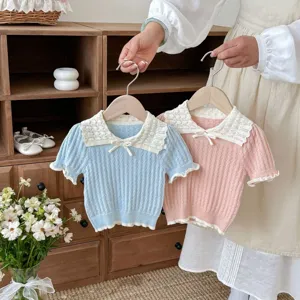 Kids knitted short sleeve top detail featuring lace collar and cute bow design in soft pastel colors.