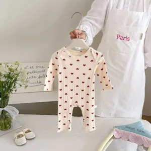 Detailed view of cute baby long sleeve romper with red heart print, soft ribbed cotton.