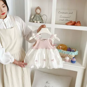 Dettaglio abito gilet in rete senza maniche per neonata, stile gonna a palloncino rosa e bianca.