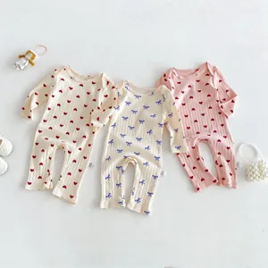Newborn baby cotton long sleeve romper detail shot with cute heart and bow prints for infant girl