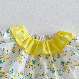 Detalle pelele bebé flores, cuello con volantes amarillo y manga corta suave algodón.