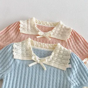 Detailed view of girls knitted short sleeve top featuring lace collar and cute bow decoration.