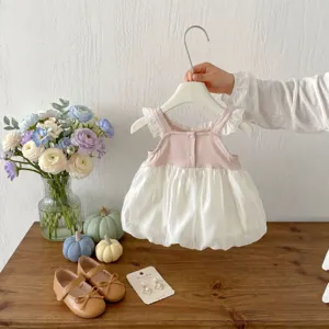 Vista dettagliata di un grazioso abito smanicato in rete per bambina in rosa e bianco.