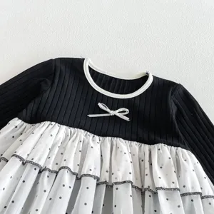 Infant baby girl detail view of long sleeve ribbed romper with white polka dot mesh skirt.