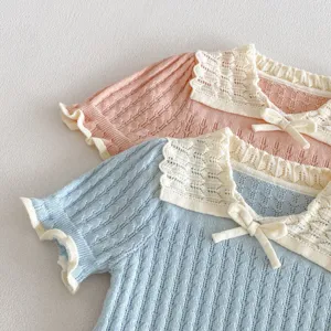 Detailed view of cute baby knit short-sleeve top with lace collar and sweet bow decoration.