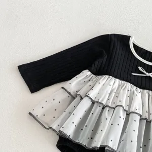 Close-up detail of infant baby girl long sleeve romper, black knit top with mesh skirt.