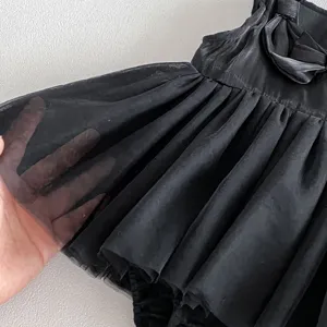 Detalle de tela de vestido de tul mesh negro para bebé niña, mameluco de verano suave y transpirable.