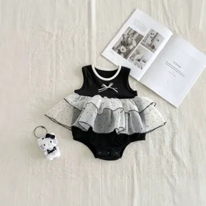 Detailed shot of infant baby girl black romper with white polka dot mesh skirt and cute bow.