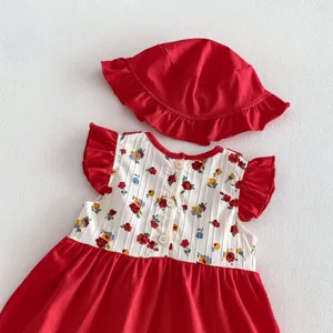 Vista dettagliata del vestito da neonato floreale rosso con cappello da sole e bottoni in legno.