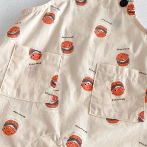 Close-up detail of cute cartoon cookie print baby romper with front pockets and buttons.