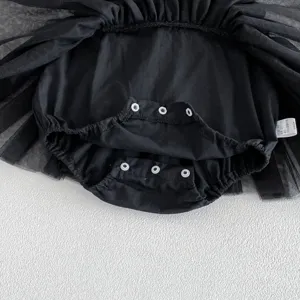 Detalle de mameluco tutu para bebé niña negro con botones a presión y falda de tul.