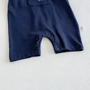 Detailed view of baby boy summer cotton romper, dark blue fabric and snap buttons.