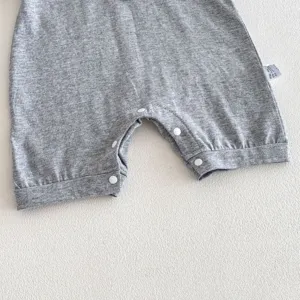 Baby romper detail shot, short sleeve cotton bodysuit, soft fabric texture close-up