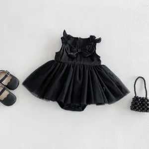 Vista detallada del pelele de bebé negro de tul, lazos bonitos, zapatos y bolso de cuentas.