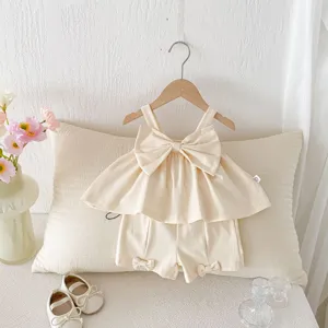 Detailed view of baby girl summer two-piece outfit featuring bow camisole top and shorts.