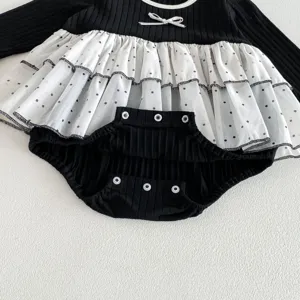 Baby girls long sleeve black romper with white polka dot mesh skirt and snap buttons.