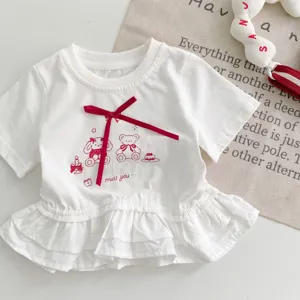 Gedetailleerd overzicht van het witte baby t-shirt met korte mouwen en een rood strikje.