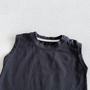 Close-up detail of sleeveless baby romper shoulder snap design in dark gray summer infant clothing.